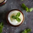 A jar of peppermint foot rub with a peppermint leaf on the top