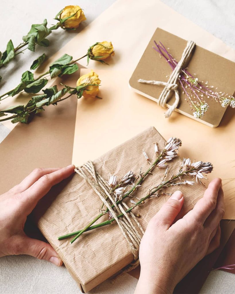 A beautifully wrapped gift with brown paper and dried flowers